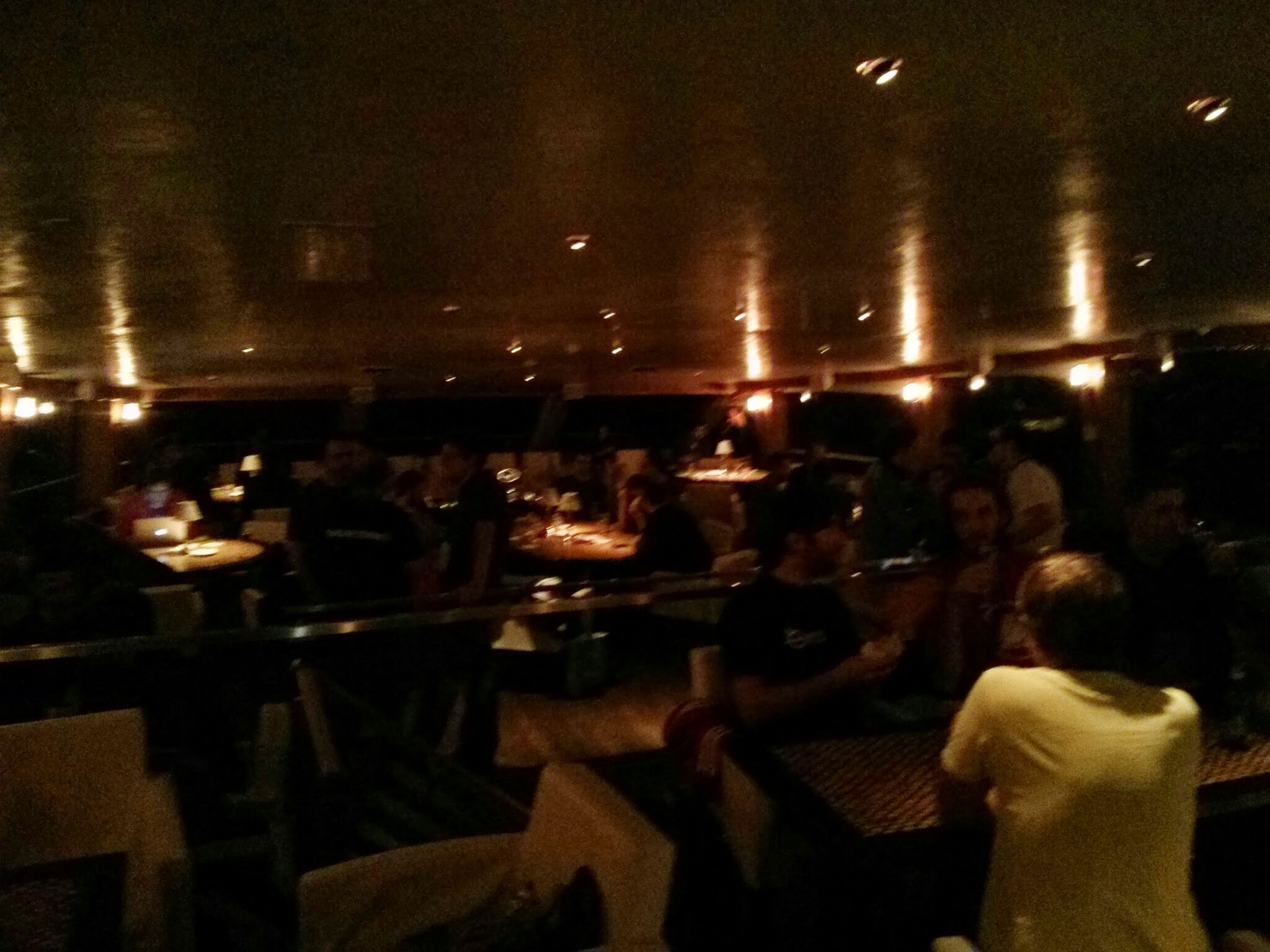 several people are sitting at tables in the dark