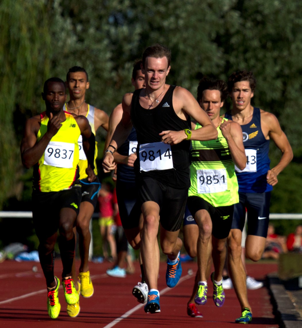 a group of men running on a race track