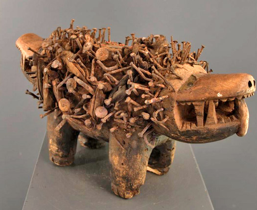a sculpture of a wooden dinosaur with teeth and legs