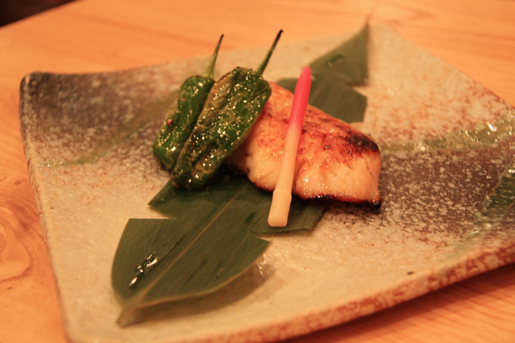 some green vegetable and a pickle on a small plate