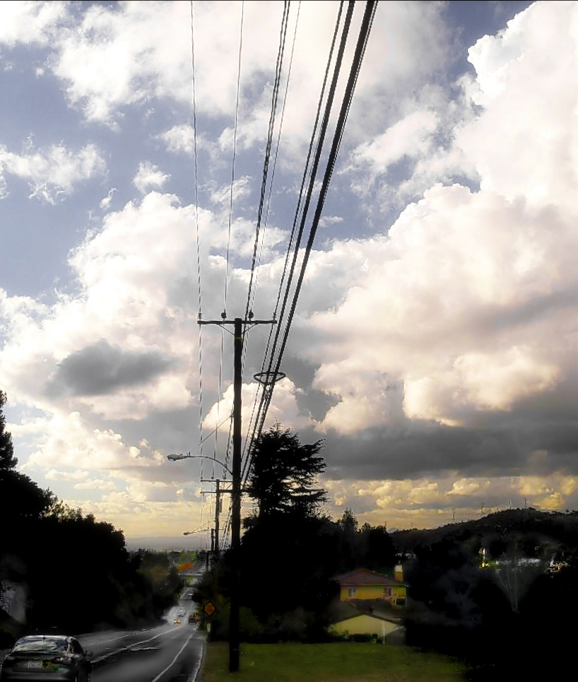 a street with power lines and cars on the road