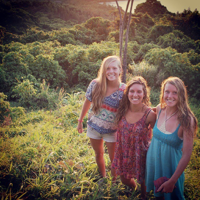 three girls posing for a picture in the field