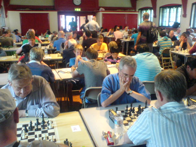 several people playing chess at tables in a restaurant