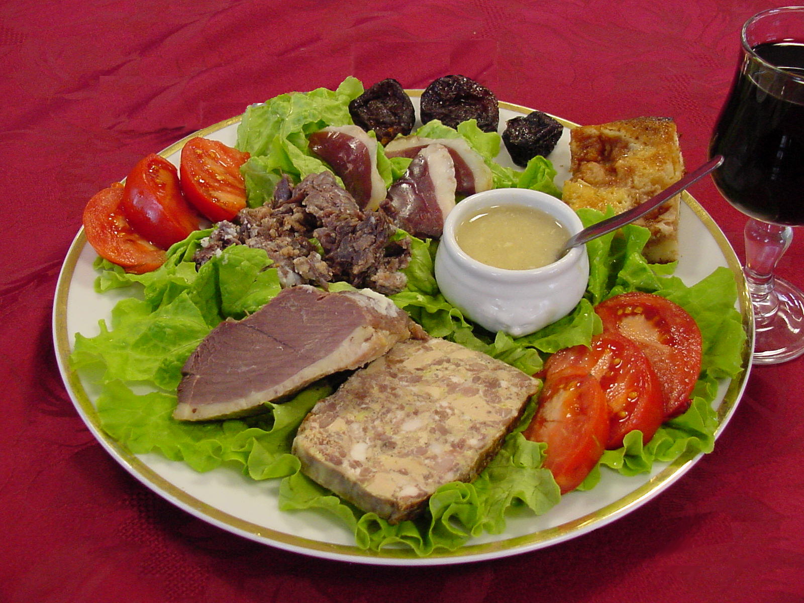 a plate with meat, tomatoes, lettuce and bread