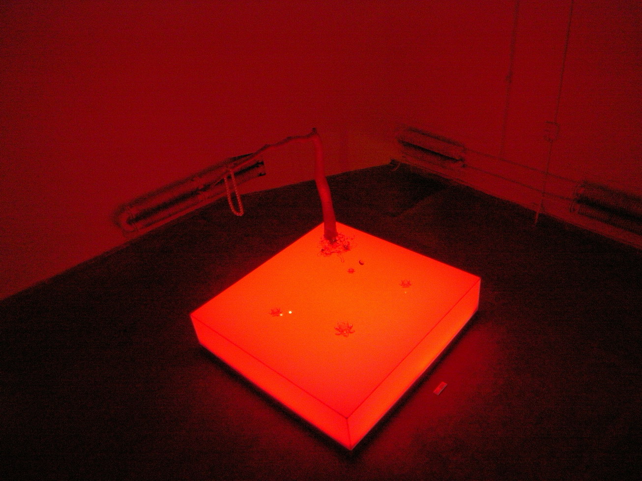 a glowing object with red lights next to a heater