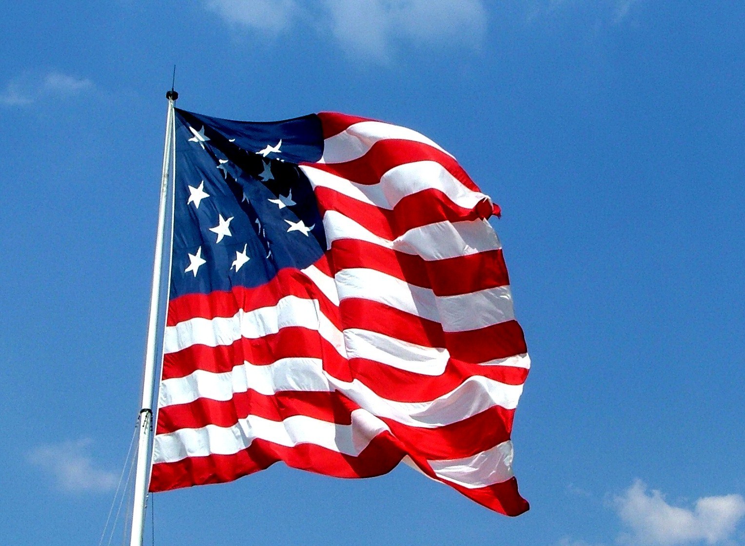 a red white and blue american flag is waving in the wind