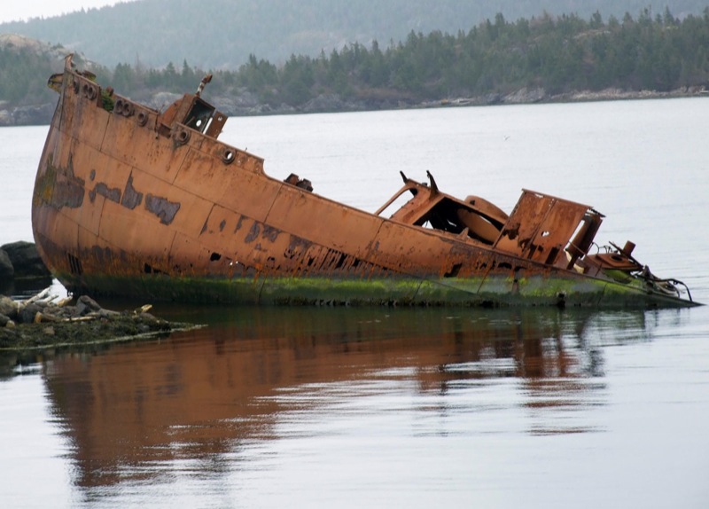 a wrecked ship is seen in the middle of water