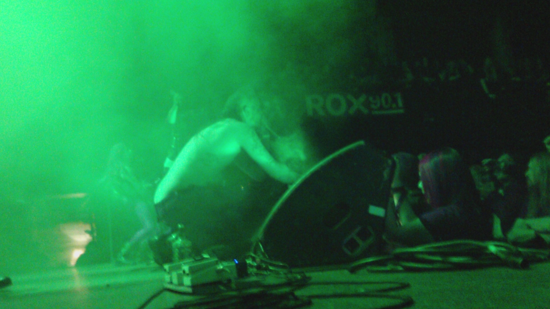 a person in a band doing soing under a green light
