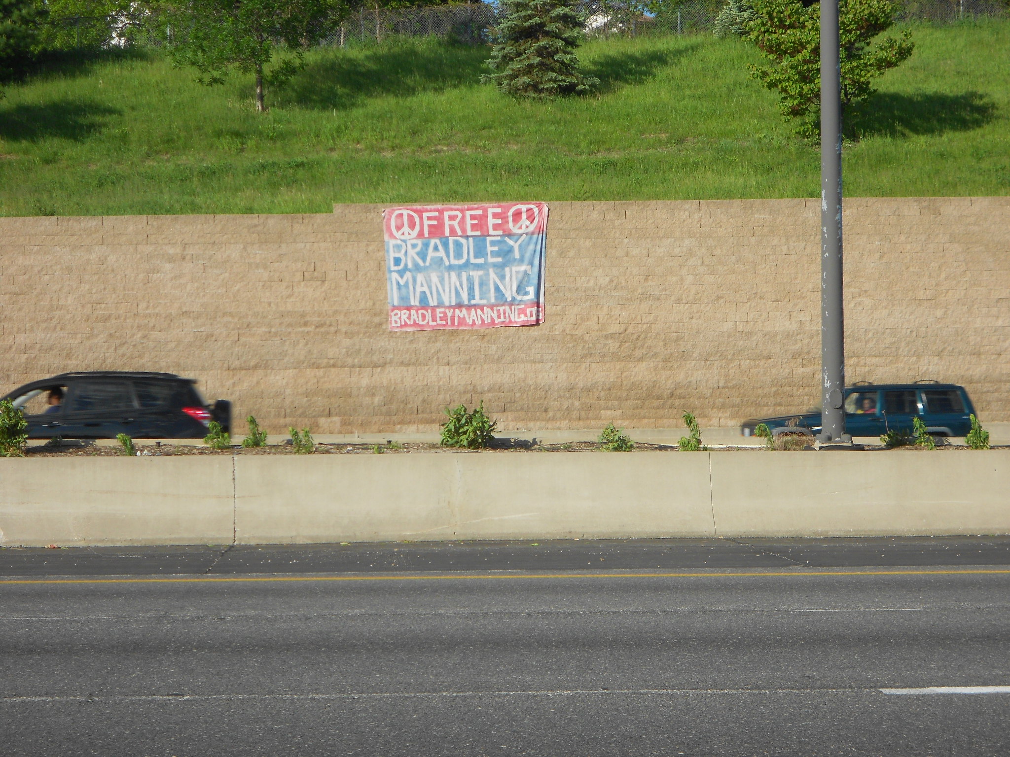 cars passing by a billboard advertising a new parking lot