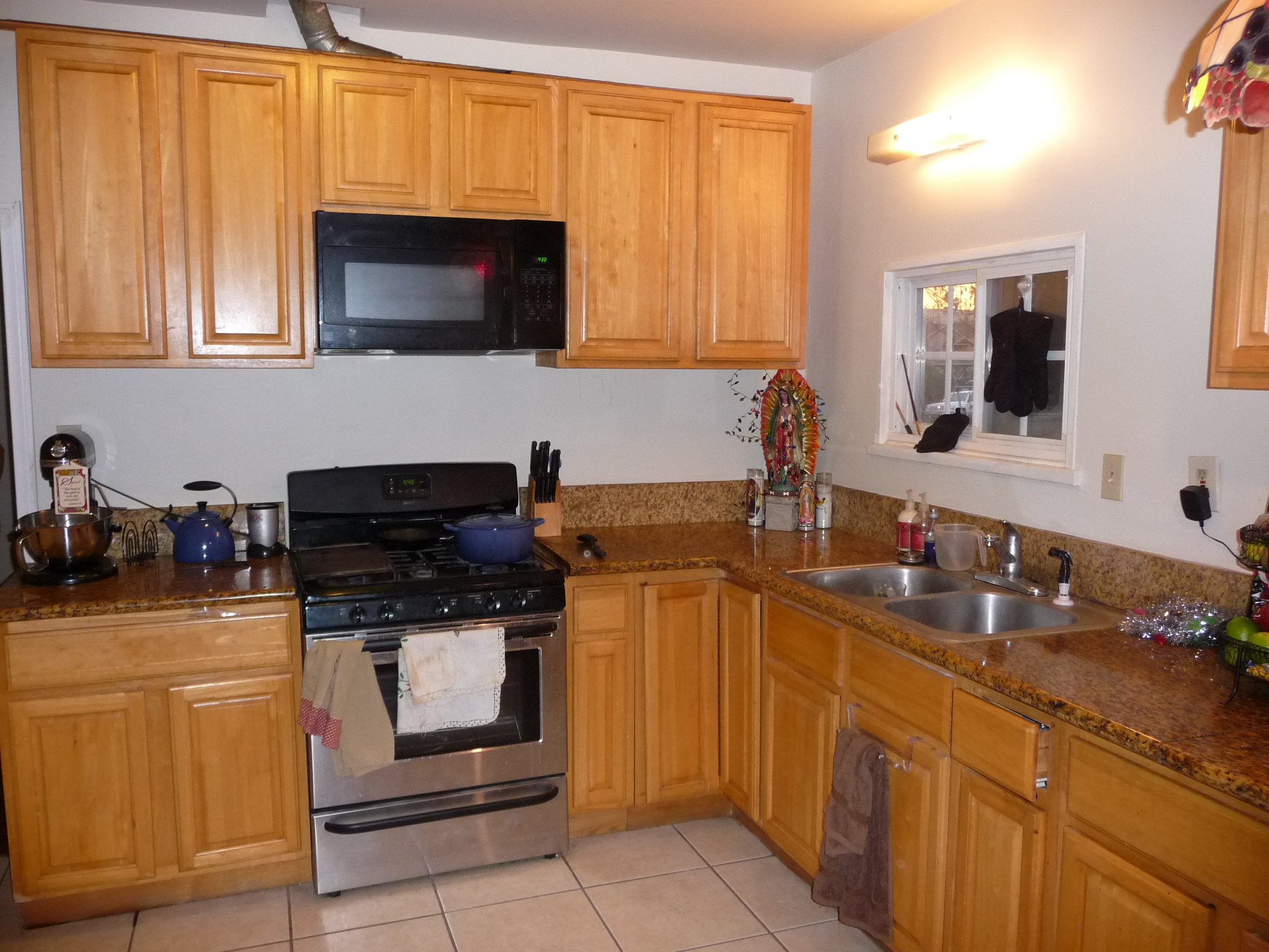 kitchen scene, wood cabinets, black microwave and dishwasher