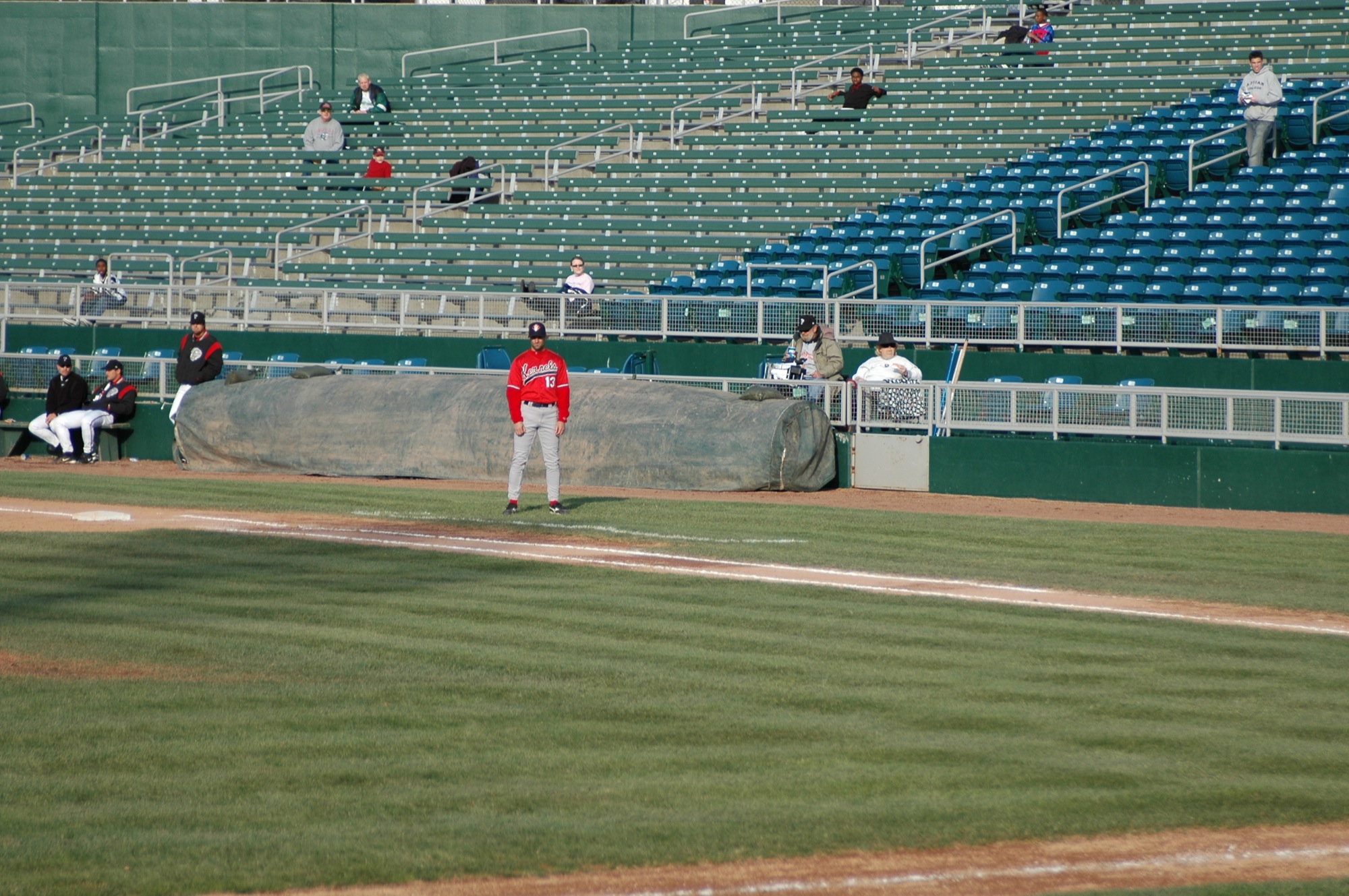 baseball player wearing red is looking into the outfield