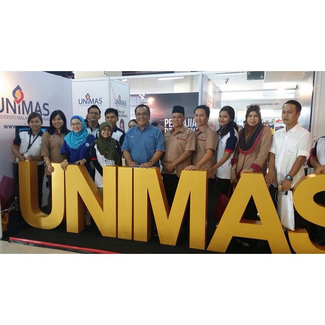 a group of people posing for a picture in front of the sign