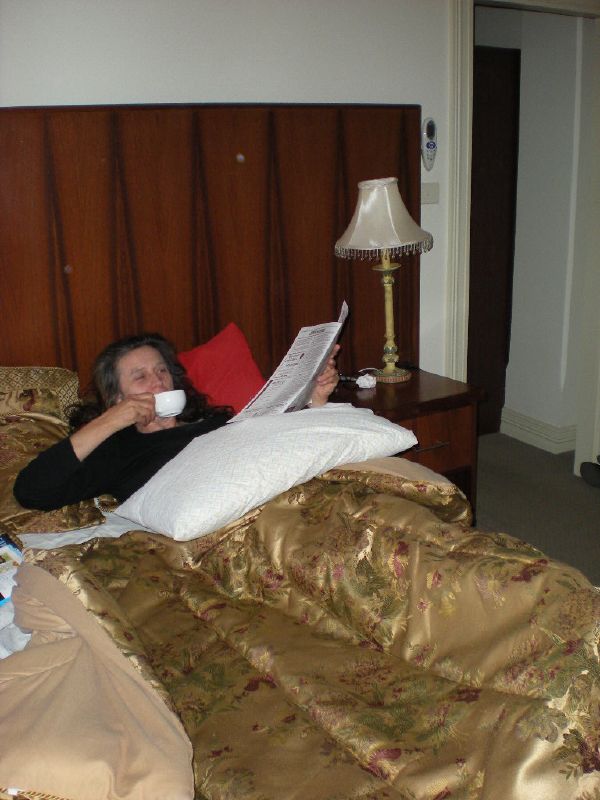a woman laying on a bed reading a magazine