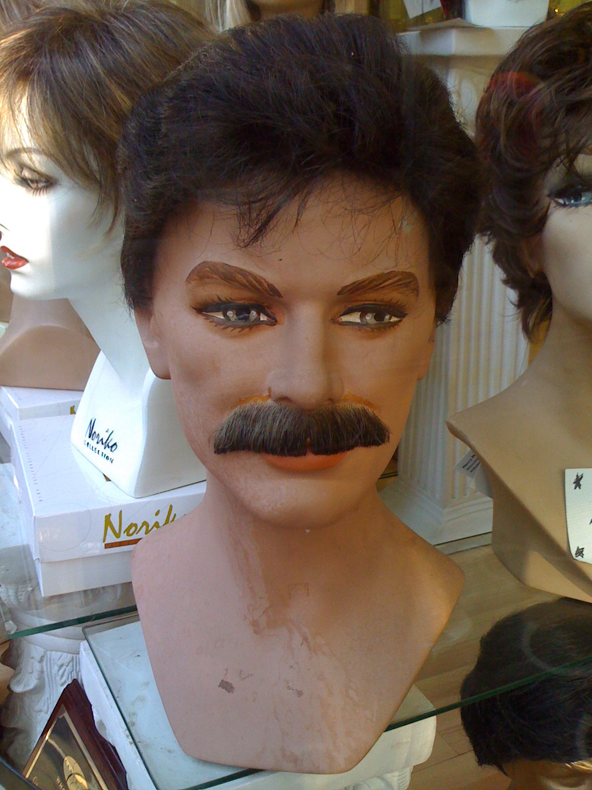 dummy with a mustache standing in a shop window