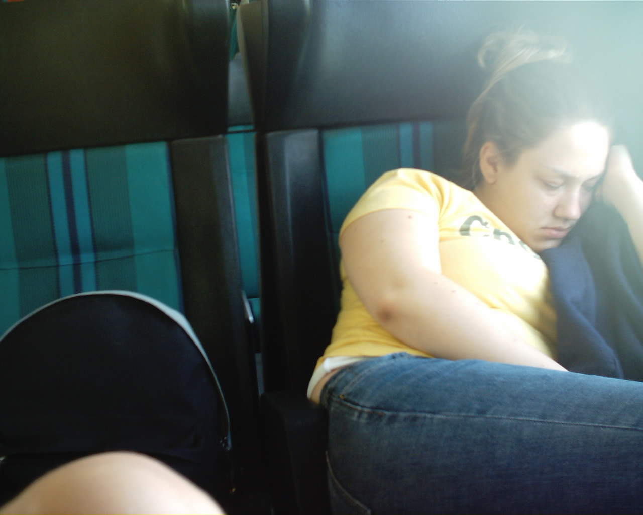 a young woman with her arm around herself sitting in an airplane