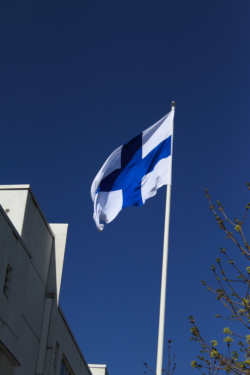 the blue and white flag is flying over a city