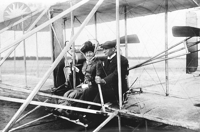 two men in an old fashioned biplane sitting together