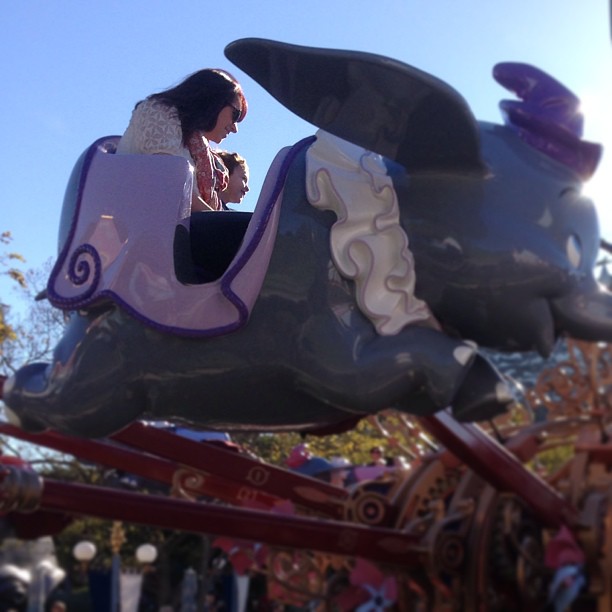 a girl riding a ride on top of a slide