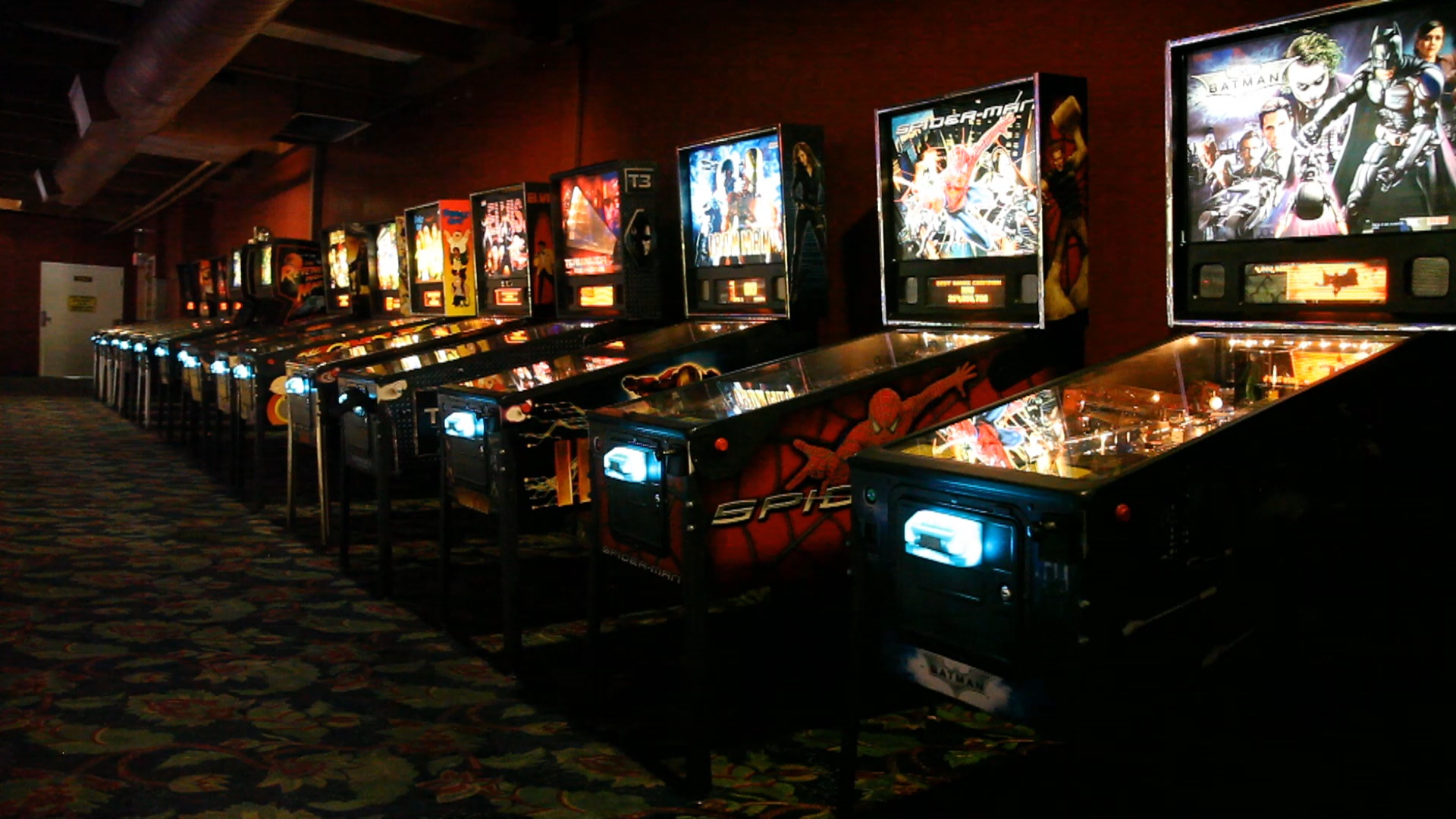 a bunch of pinball machines lined up on a wall