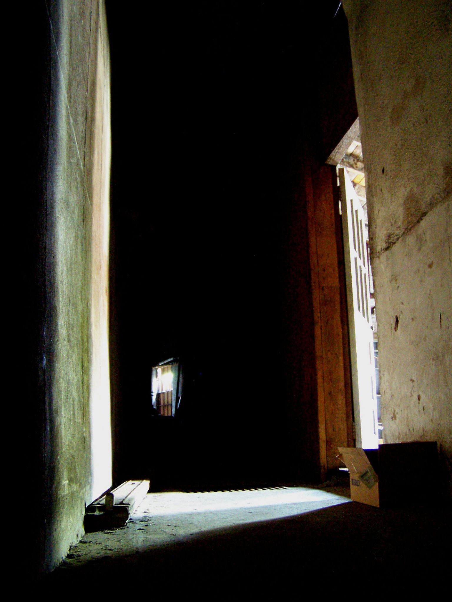 a narrow hallway leads to a small window