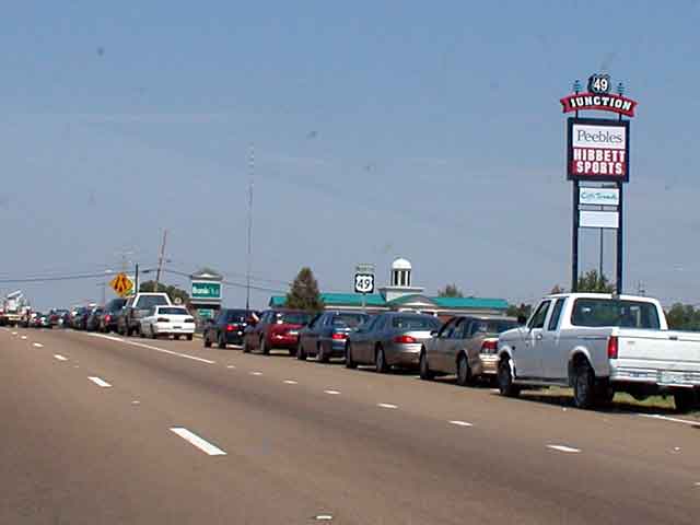 cars line up along a street in front of the kentucky motor sports sign
