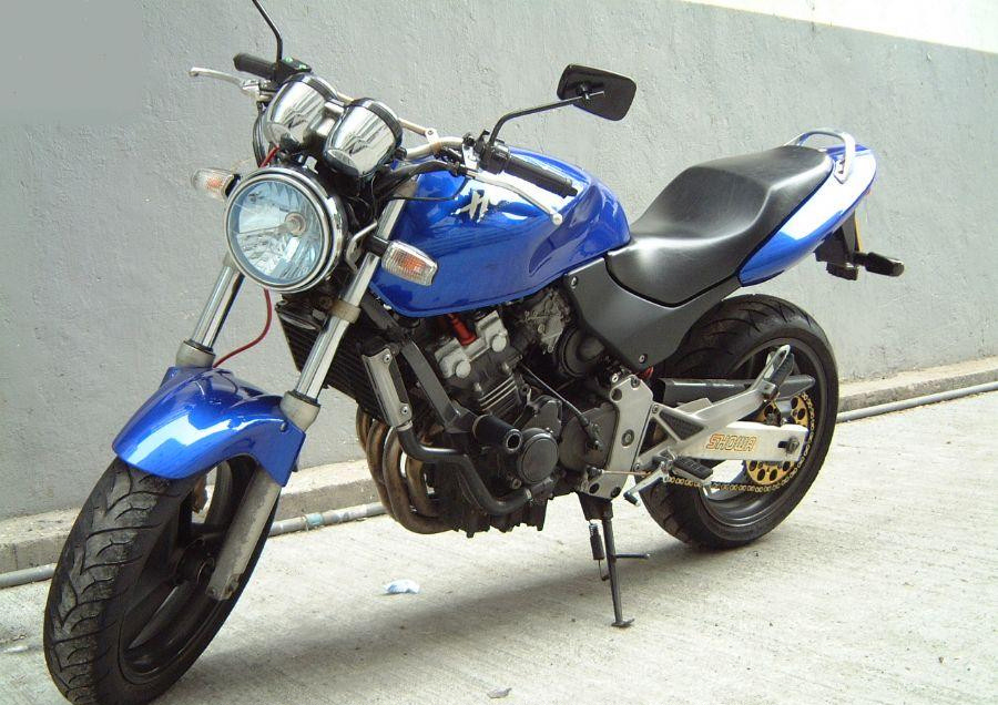 a blue and black motorcycle parked in front of a wall