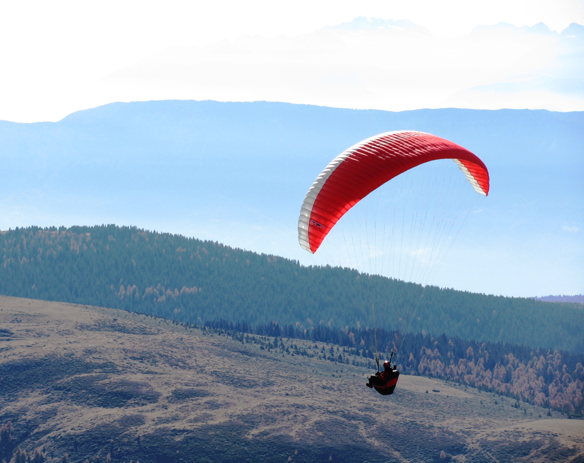 two men para sailing on top of a mountain