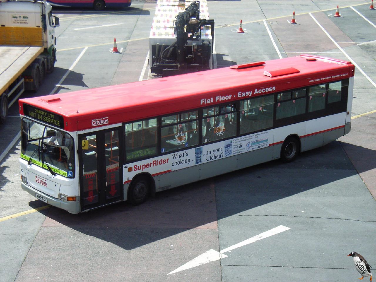 a big long bus parked next to a tractor