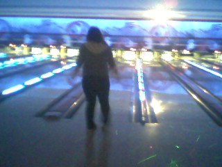 a girl is standing in the distance on a bowling game