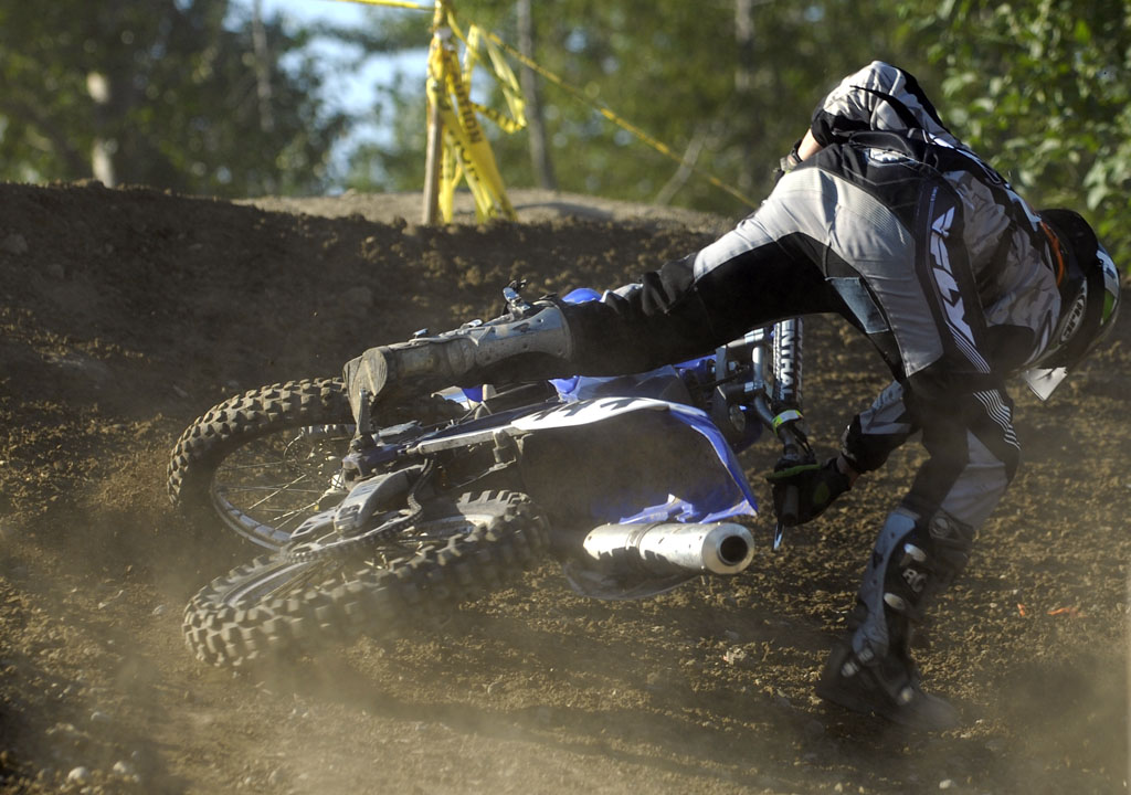 man riding on motorbike up hill in mud