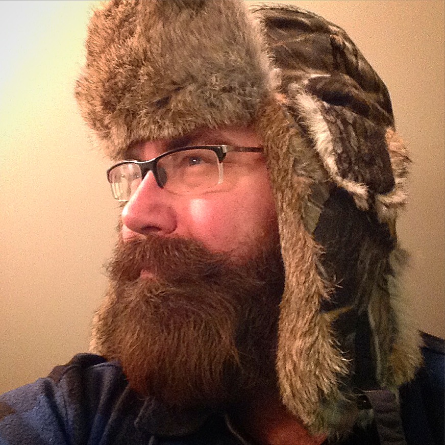 a man with glasses, hat and a long beard wearing glasses