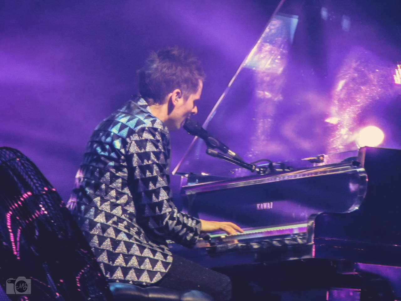 the man is playing his piano while on stage