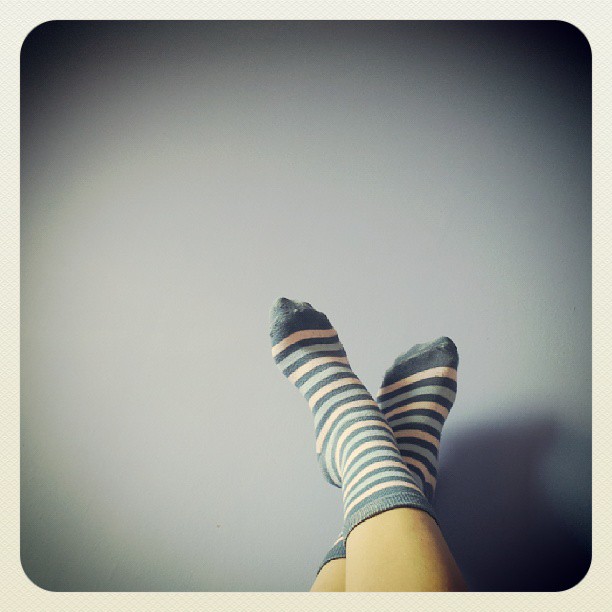 a girl with her legs up and showing off her legs in striped socks