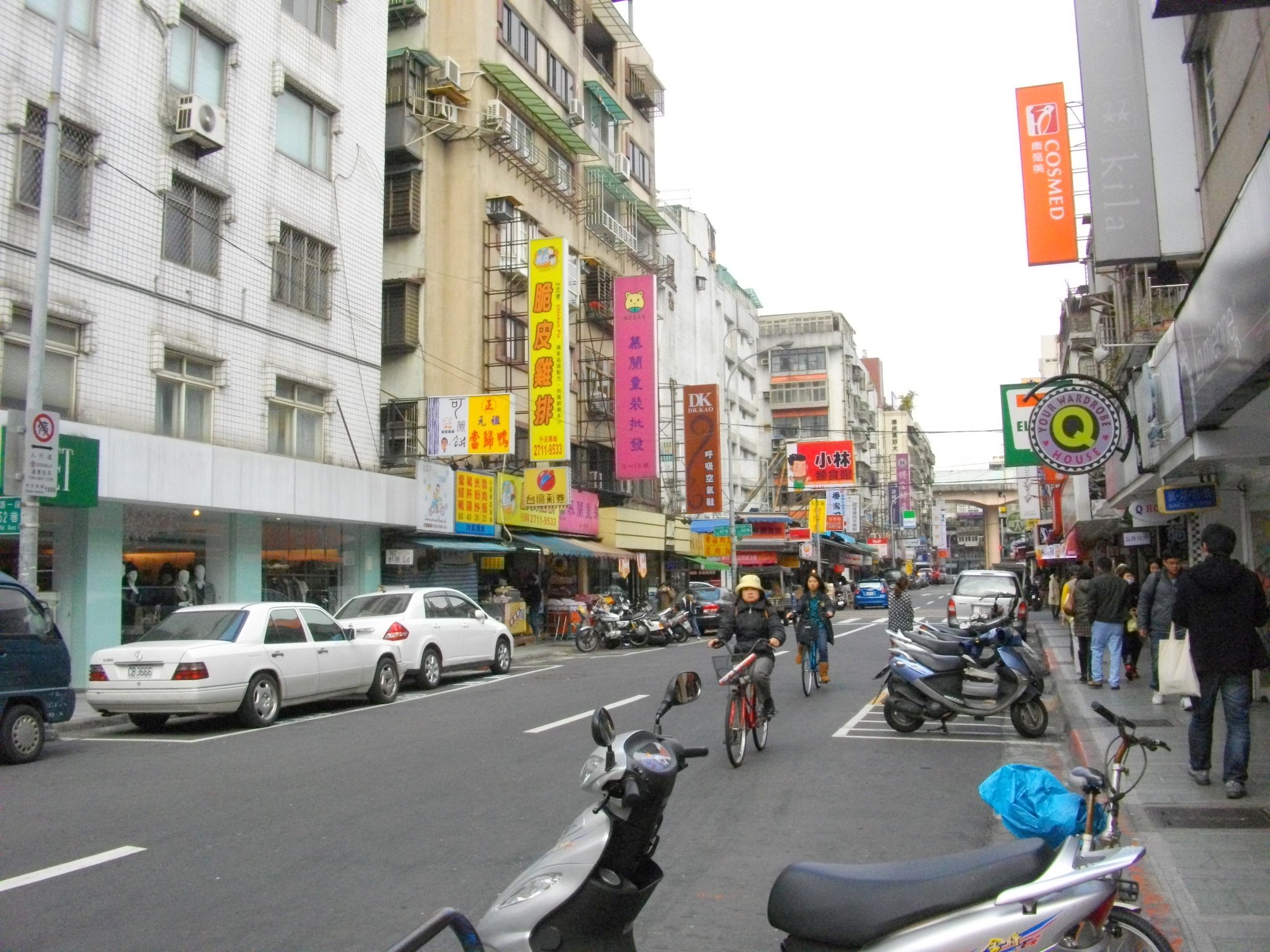 people riding their bikes down the street and cars