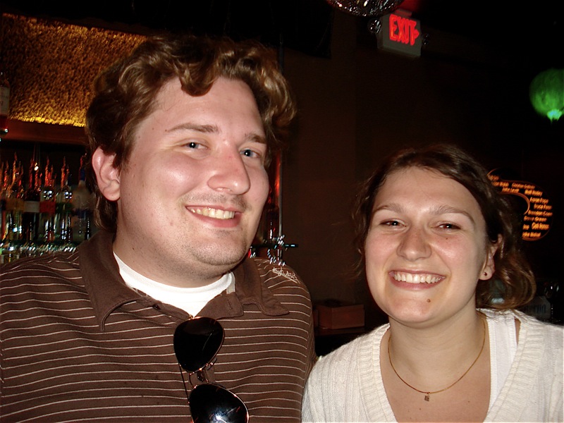 a man and woman smiling together in a bar