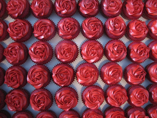 a white cake filled with red cupcakes covered in frosting