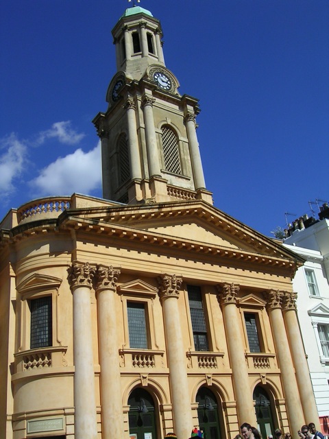 a large building with a clock tower next to some buildings