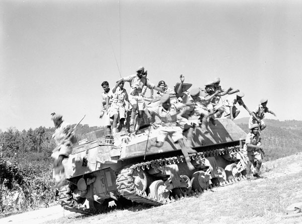 a group of soldiers sitting on top of an army tank