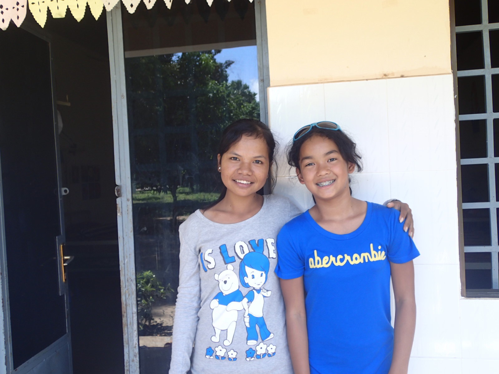 two girls are standing in front of a door