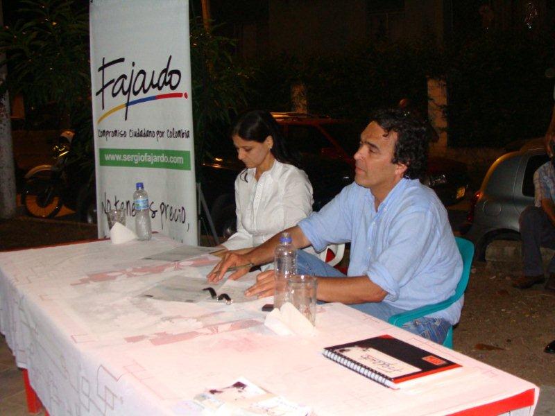 a man and woman sitting at a table with papers