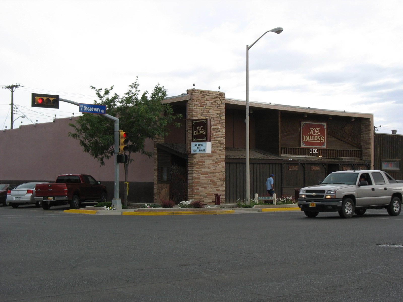 a stoplight with cars in front of a building