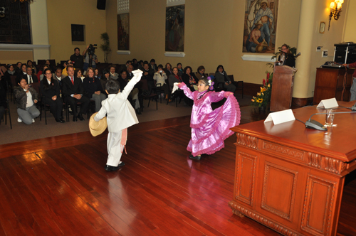 two children dancing in a large room with people
