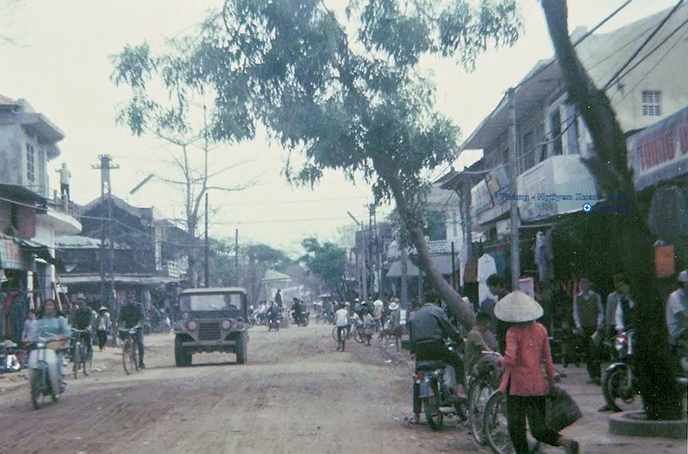 a street lined with people riding bicycles on a dirt road