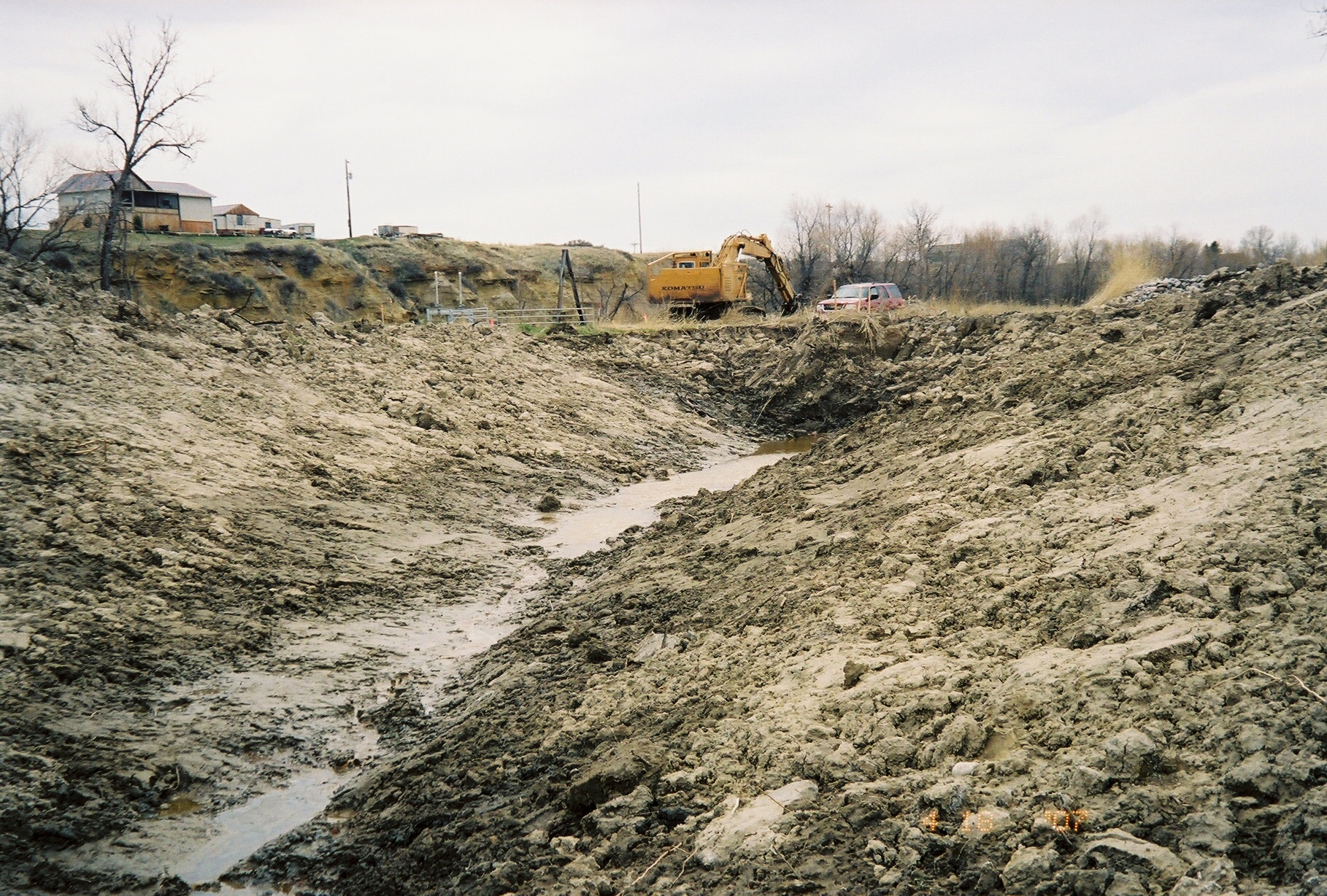 an empty ditch filled with dirt sitting in the middle of a hillside