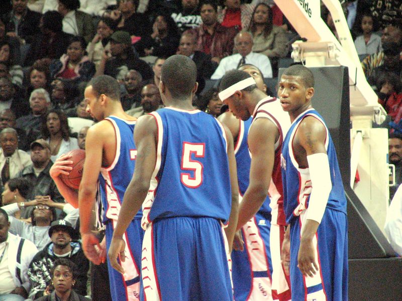 a group of basketball players standing together in front of an audience