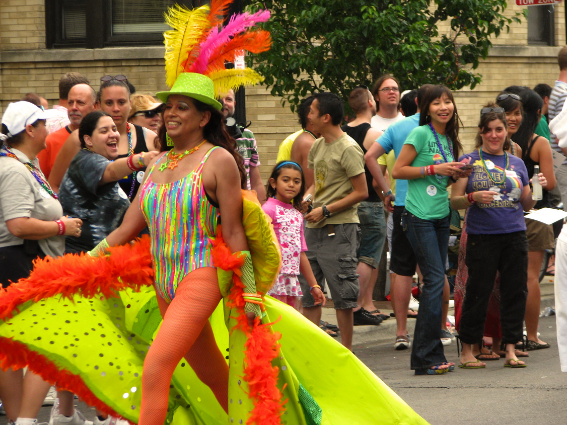 a woman wearing brightly colored clothing and headgear in front of a crowd