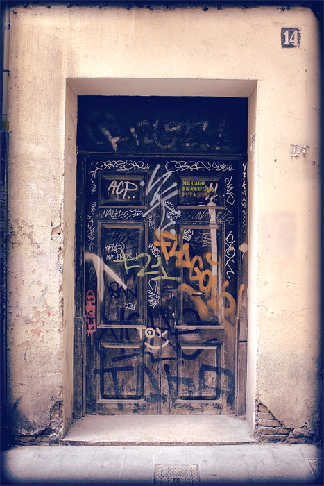 graffiti is sprayed onto the front door of an old building