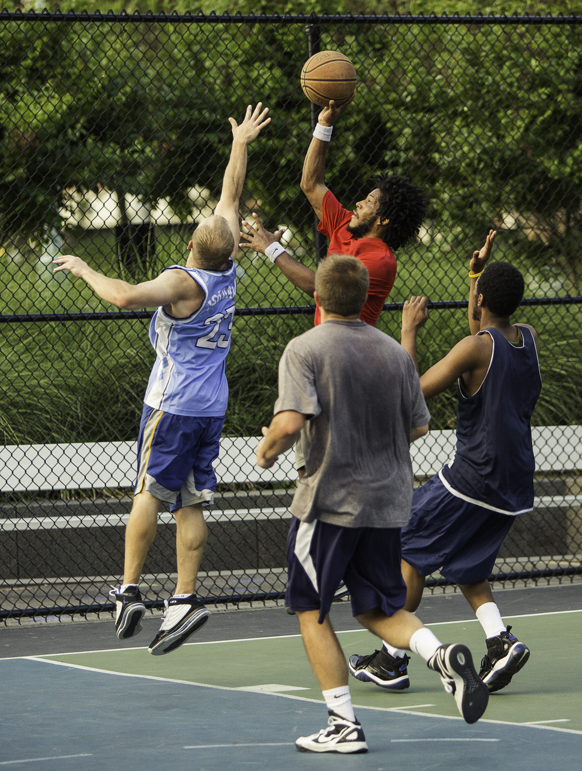 men on court jumping up and catching the basketball