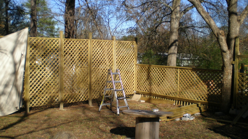 a fenced area with wood steps and an old picnic table