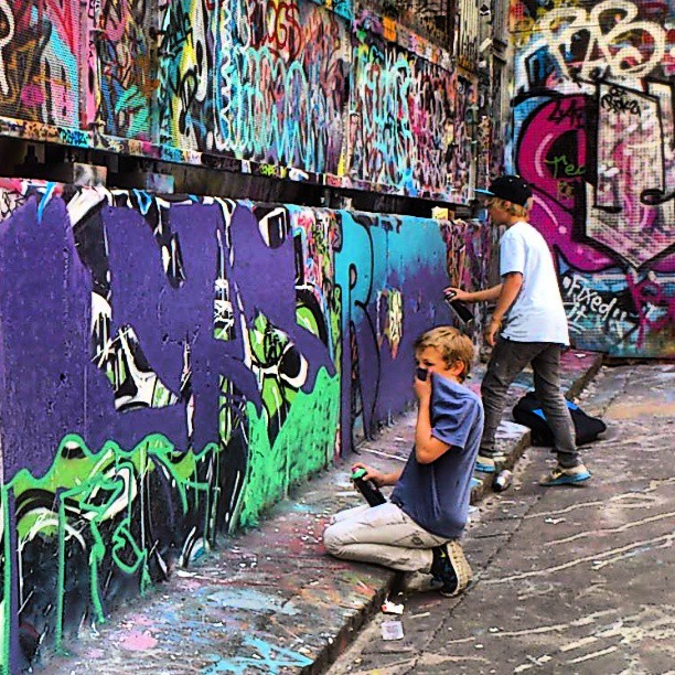 the s are painting a graffiti wall outside